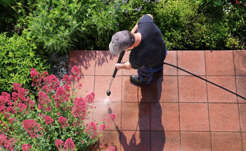 Person pressure washing a patio